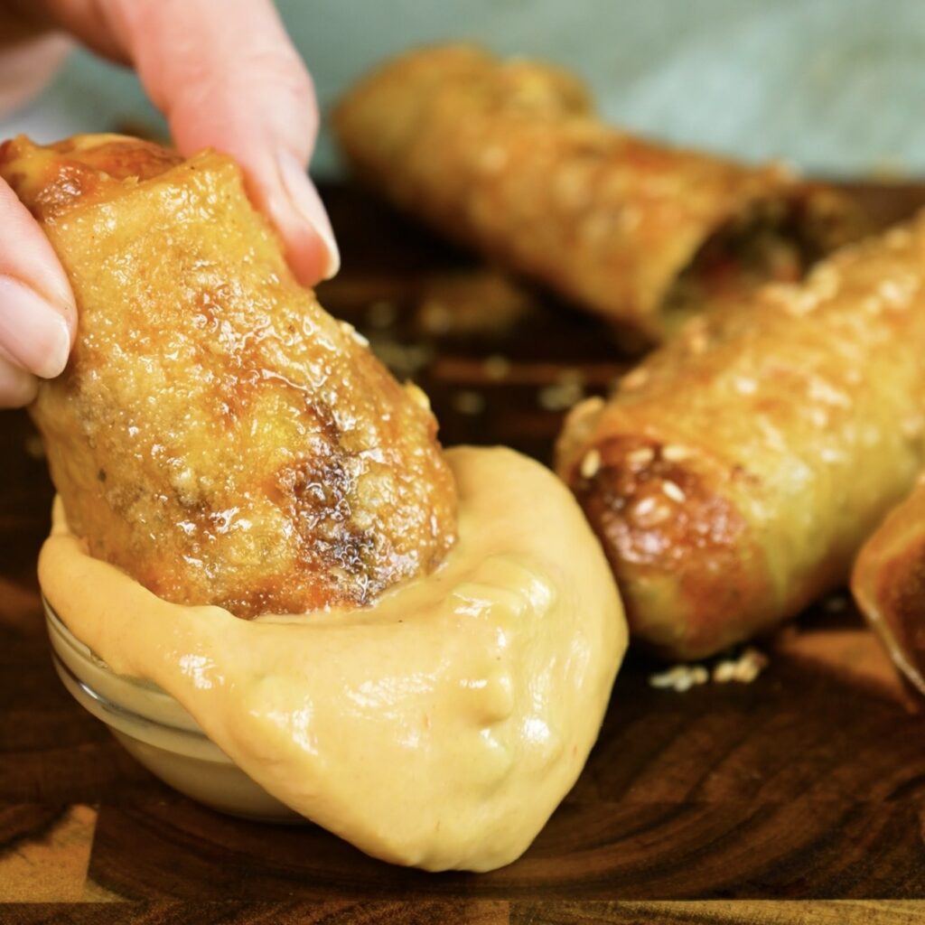 Rice paper cheeseburger roll dipped in burger sauce