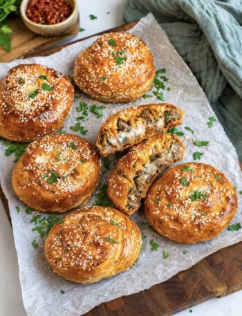 Cheesy beef filo swirls served on a wooden board.