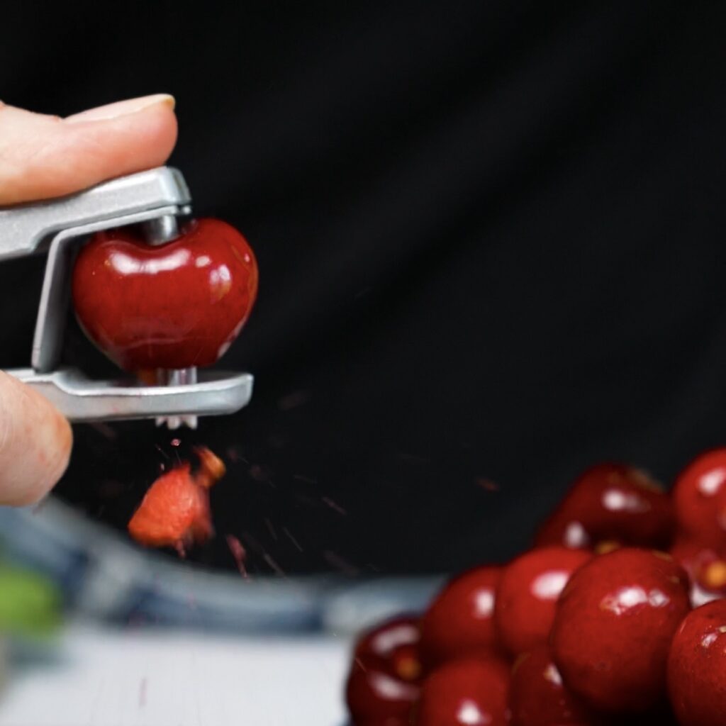 Pitting fresh cherries for Cherry Ricotta Rice Paper Dumplings.