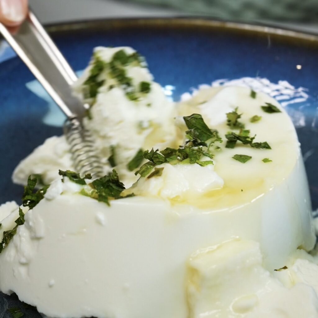 Mixing ricotta filling with honey, mint and vanilla for cherry rice paper dumplings.