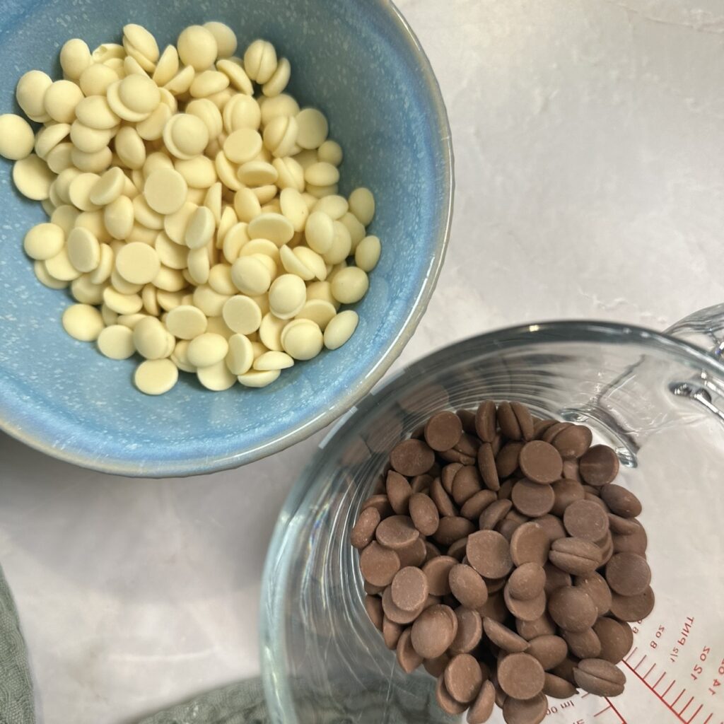 White chocolate and milk chocolate in two separate bowls before melting.