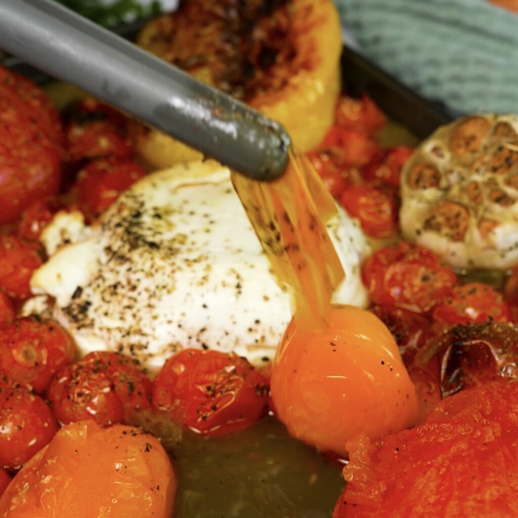 Peeling the loosened skin from roasted large tomatoes before blending the pasta sauce.