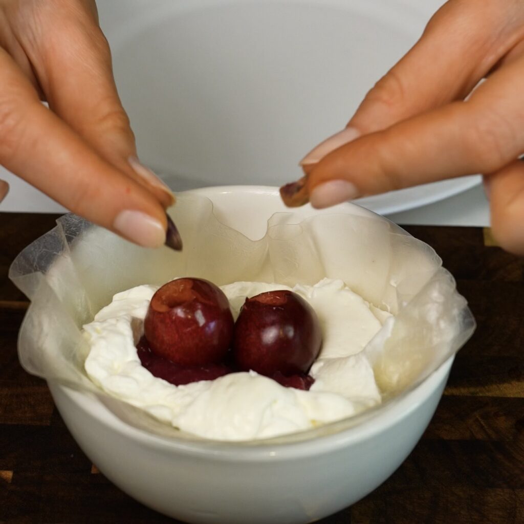 Cream, cherry sauce and fresh cherries added to softened rice paper