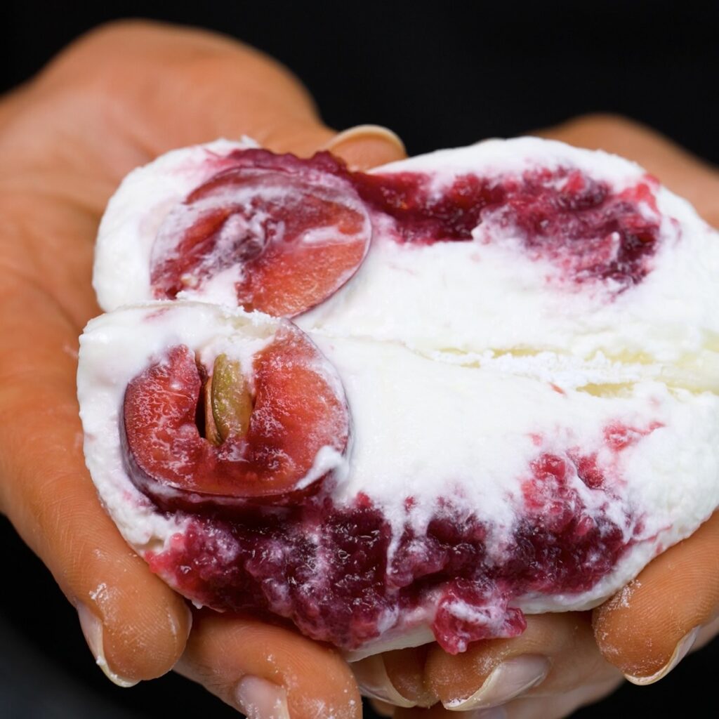 Cherry Rice Paper Mochi sliced in half to show the creamy cherry filling