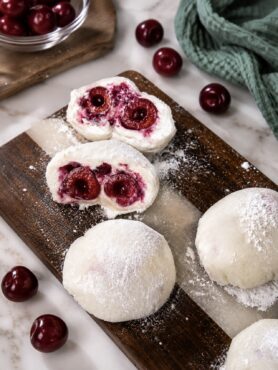 Cherry Rice Paper Mochi arranged on a wooden board with one sliced in half