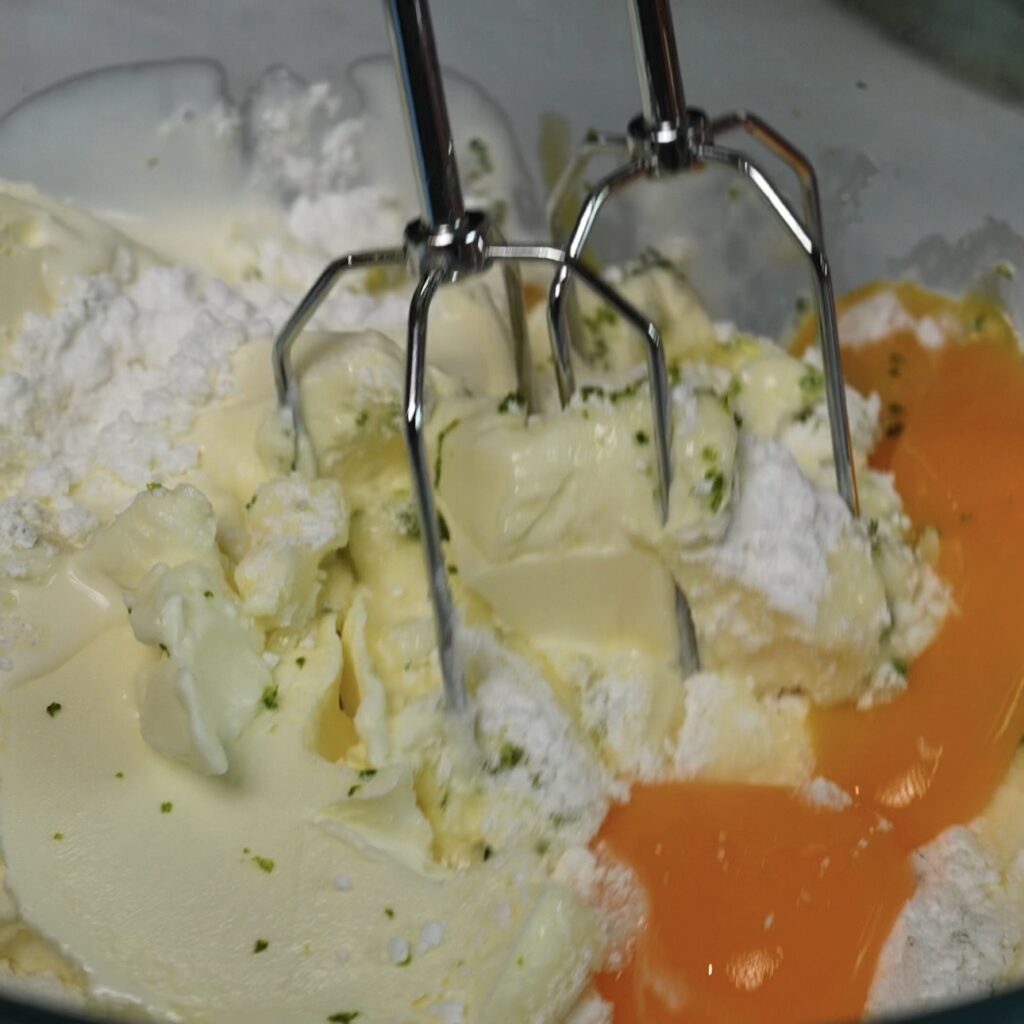 Whisking the cheesecake filling with an electric mixer