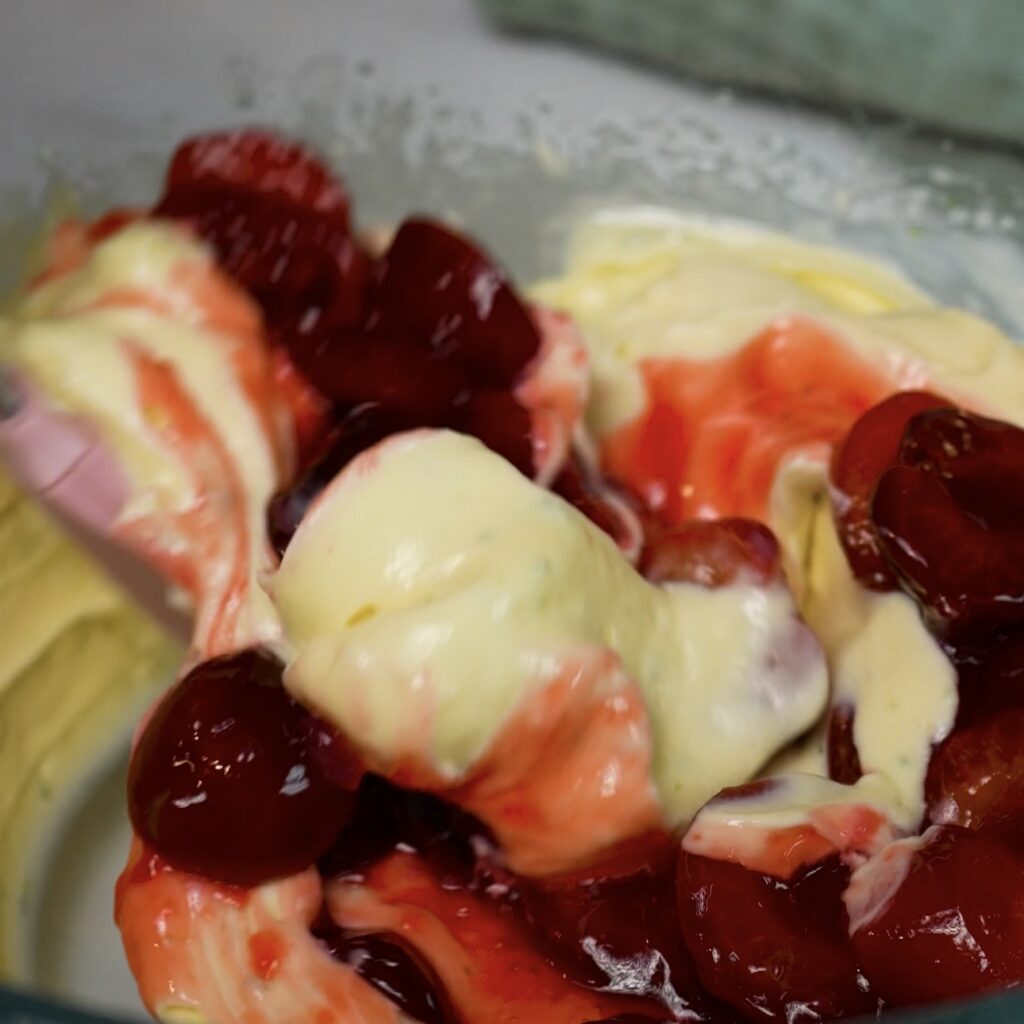 Folding cold cherry compote into the cheesecake filling