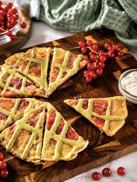 Redcurrant rice paper pancake cut into wedges and served on a wooden board