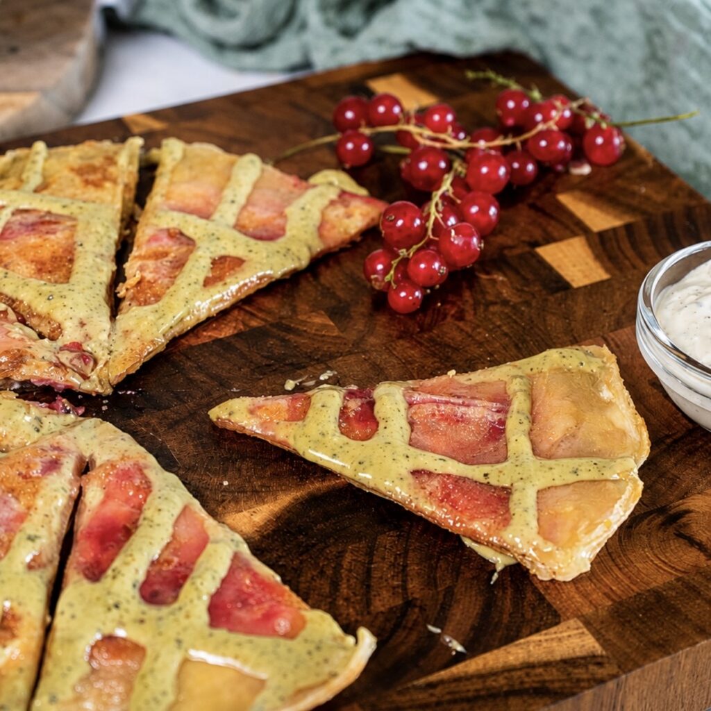 Redcurrant rice paper pancake cut into wedges and served on a wooden board.