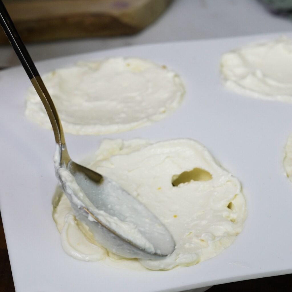 Blueberry filling being covered with more cottage cheese mixture in a silicone mould.