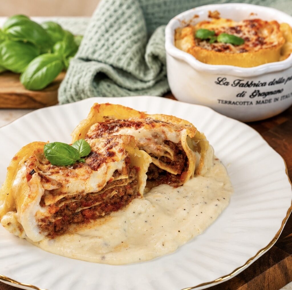 Lasagna-Stuffed Caccavelle sliced in half and served on a plate, revealing layers of beef ragù, lasagna and béchamel sauce.