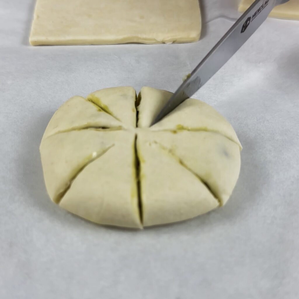 Cutting a flattened puff pastry round to create the flower shape