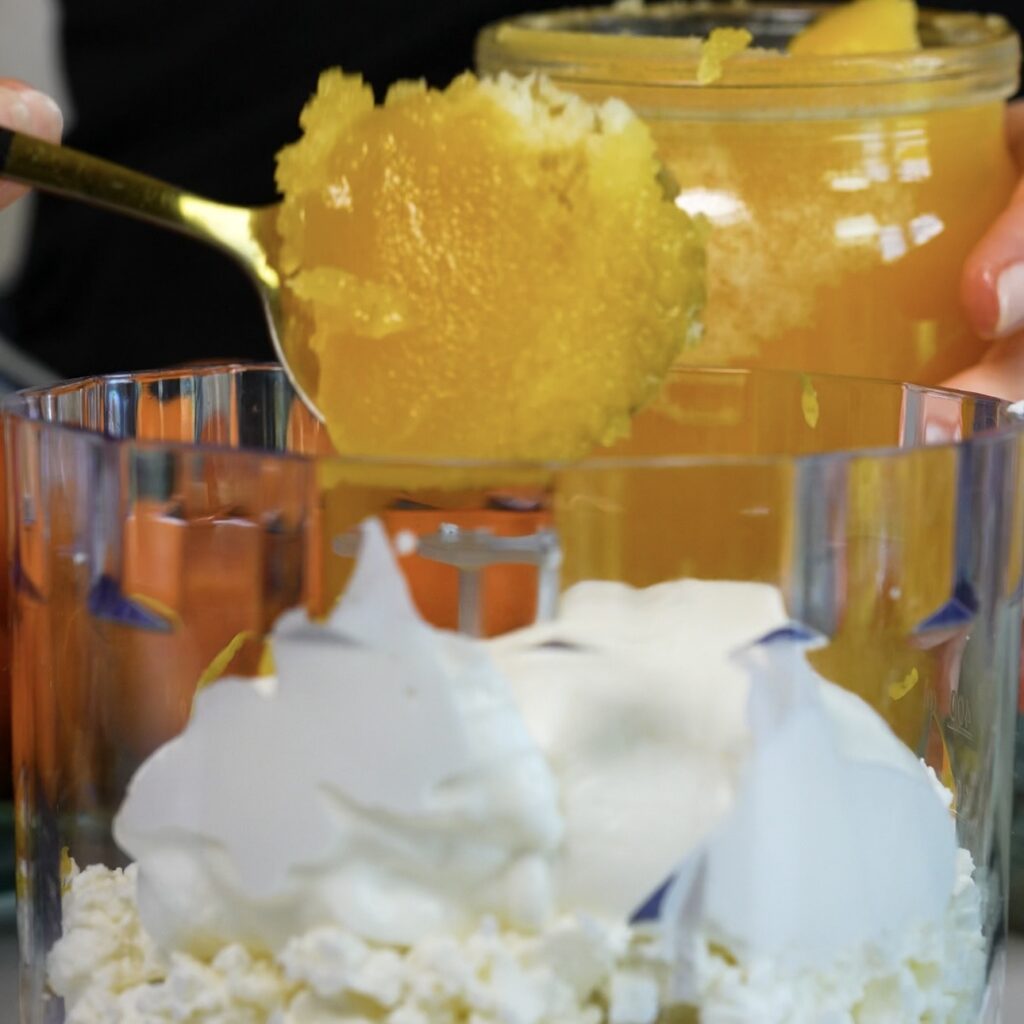 Blending cottage cheese, yogurt, egg yolks, lemon zest and honey until smooth for the Cottage Cheese Apricot Galette filling
