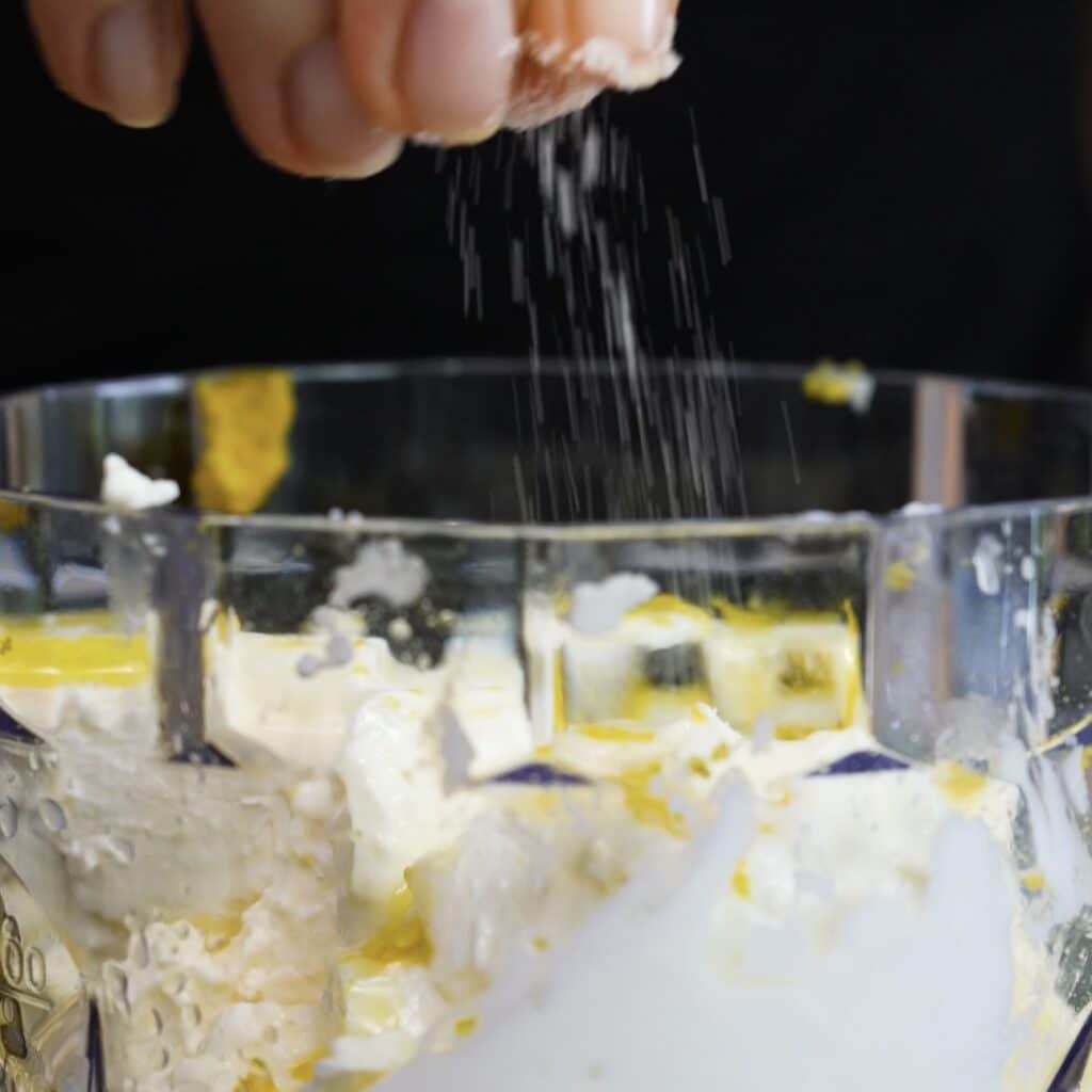 Feta, yogurt, lemon juice, lemon zest and olive oil added to a food processor for whipped feta.