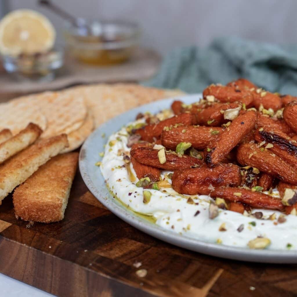Whipped feta topped with honey-roasted baby carrots and crushed pistachios, served with toasted bread.