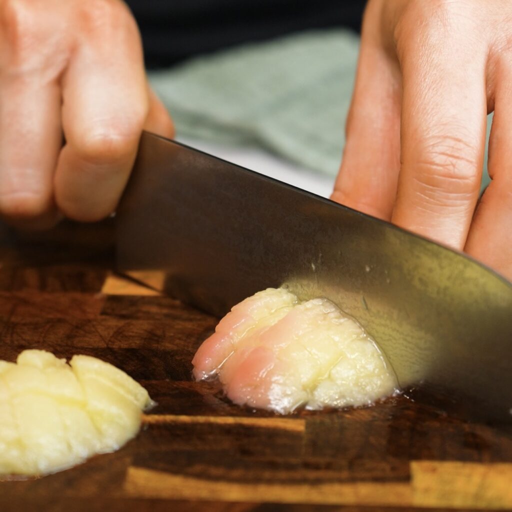 Chopping peeled peaches into small pieces for Sticky Peach and Pistachio Buns.