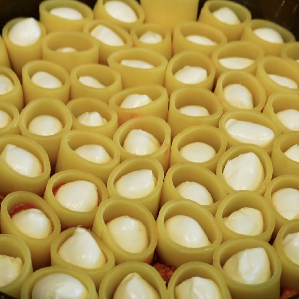 Paccheri arranged over Beef Ragù and filled with mini mozzarella balls.
