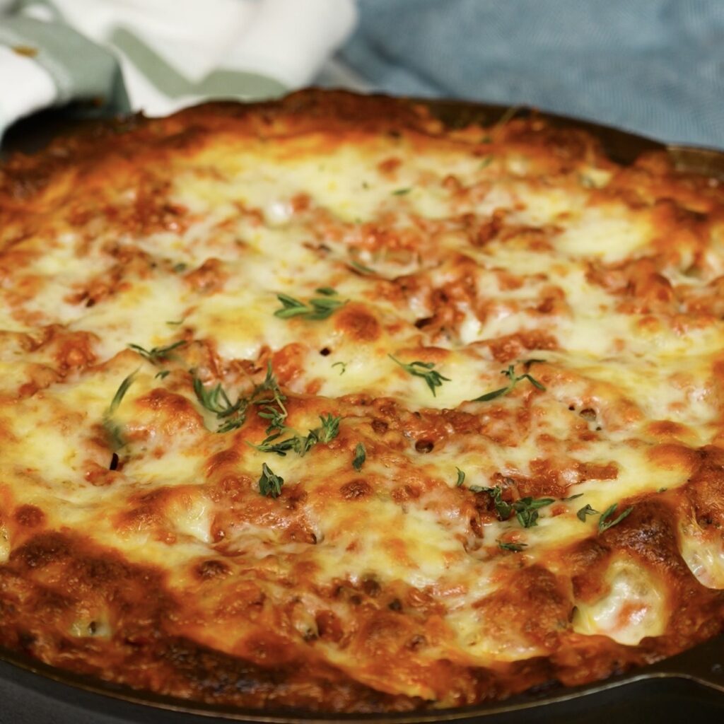 Sprinkling fresh thyme leaves over baked Mozzarella-Stuffed Paccheri.