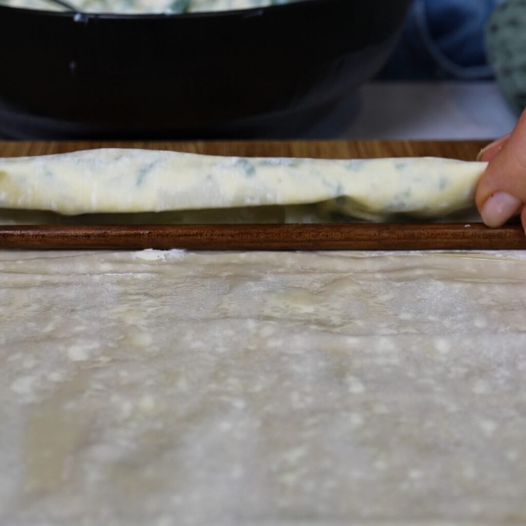 Rolling the filo pastry around a chopstick to shape the doughnut