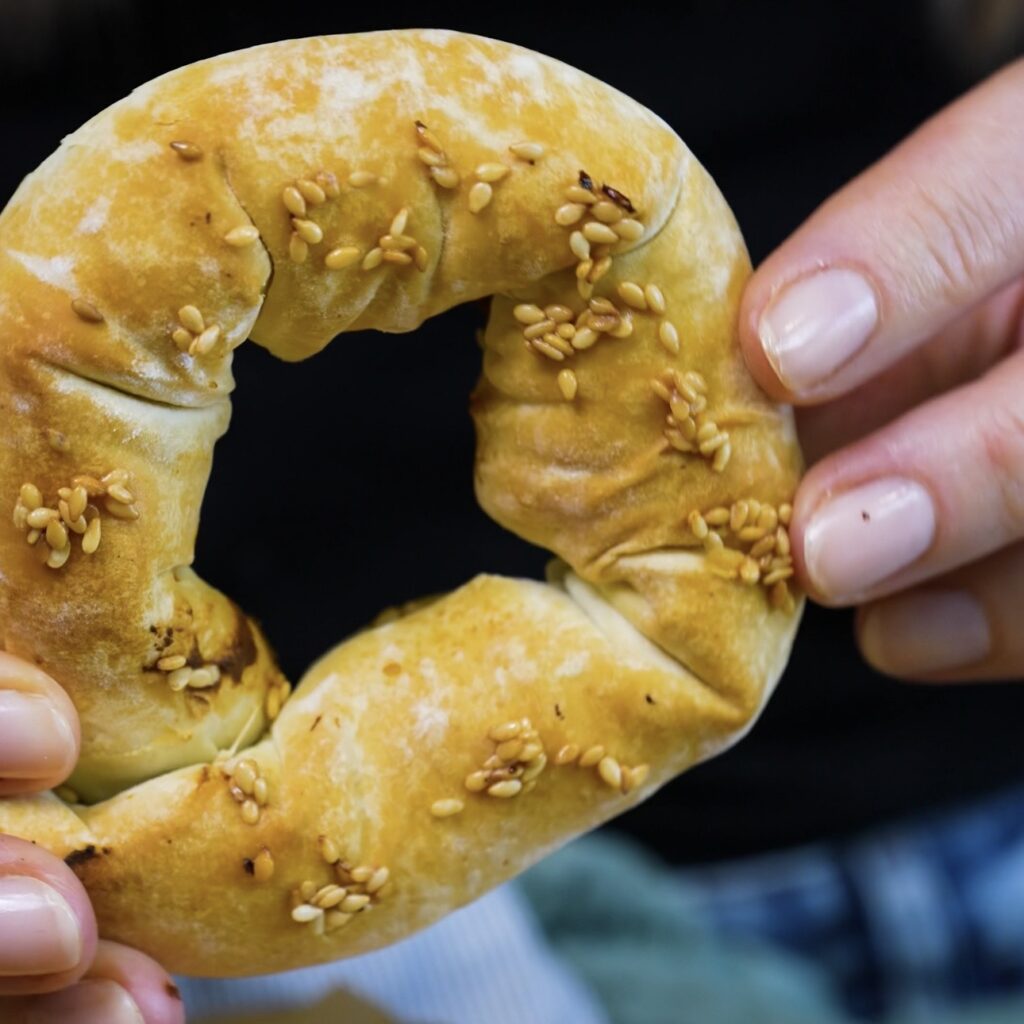Hands holding a freshly baked Feta and Spinach Filo Doughnut