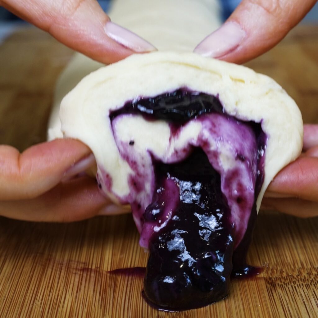 Cutting blueberry roll dough into individual pieces