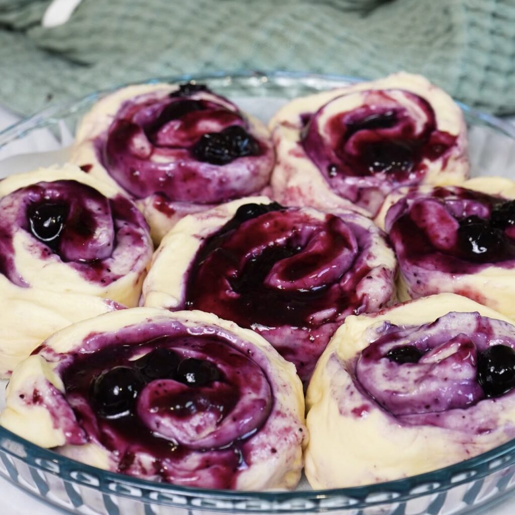 Blueberry rolls arranged in a baking dish before rising