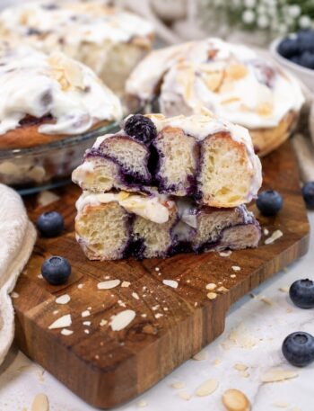 Blueberry roll sliced in half on a wooden board