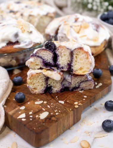 Blueberry roll sliced in half on a wooden board