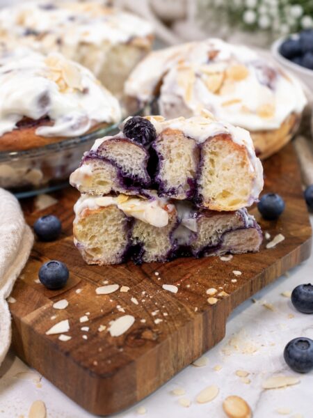 Blueberry roll sliced in half on a wooden board