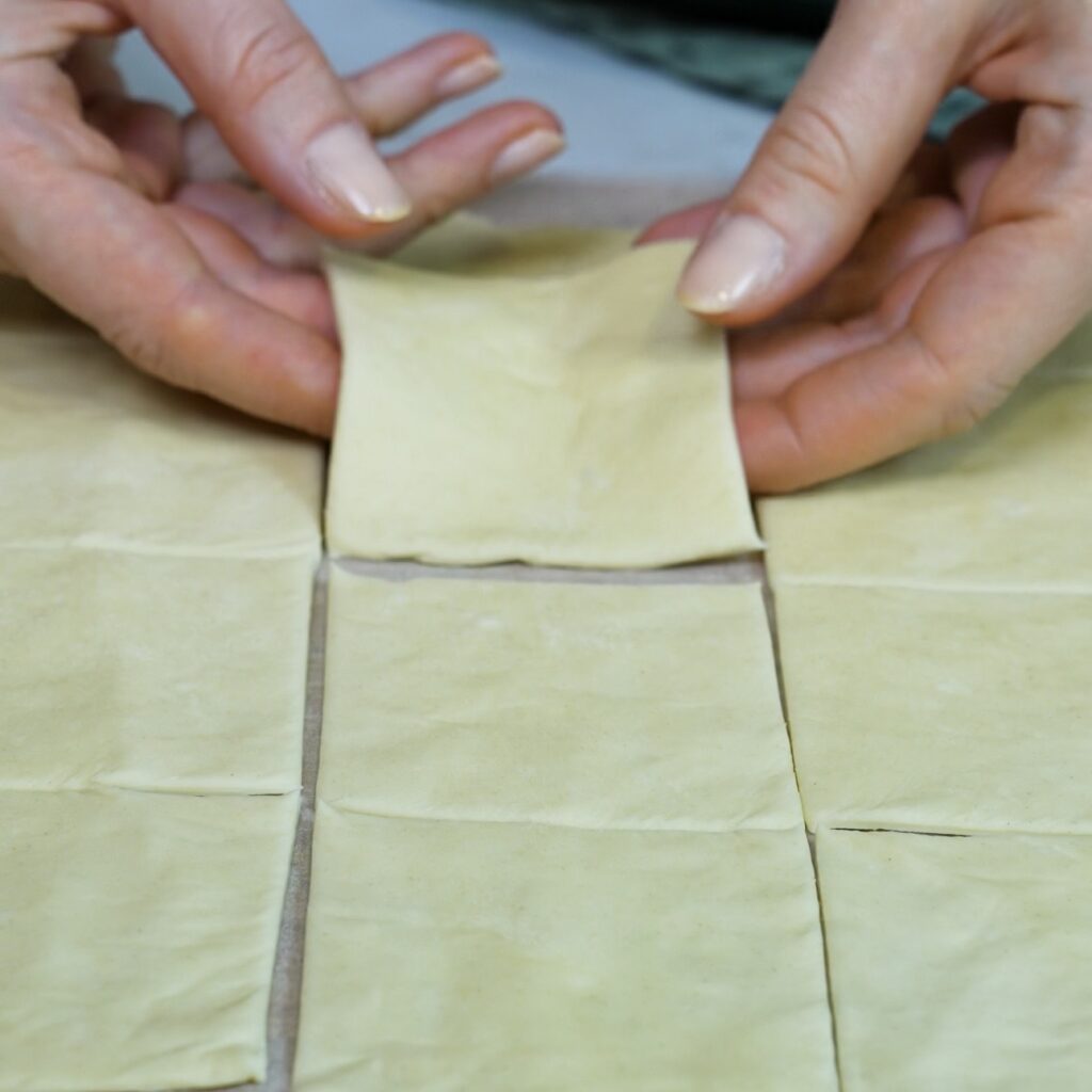 Puff pastry rectangle cut into equal squares for Apricot Mascarpone Puffs.