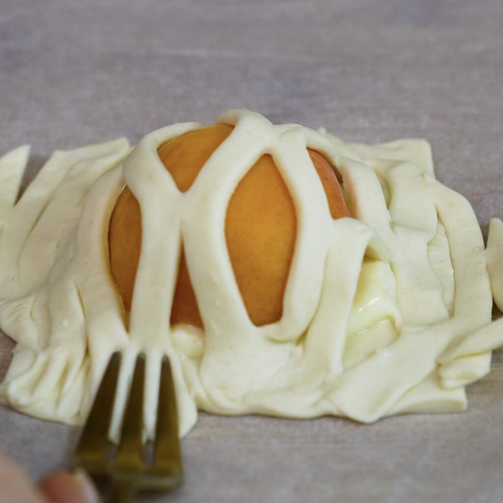 Pressing the edges of the filled puff pastry with a fork to seal the Apricot Mascarpone Puffs.