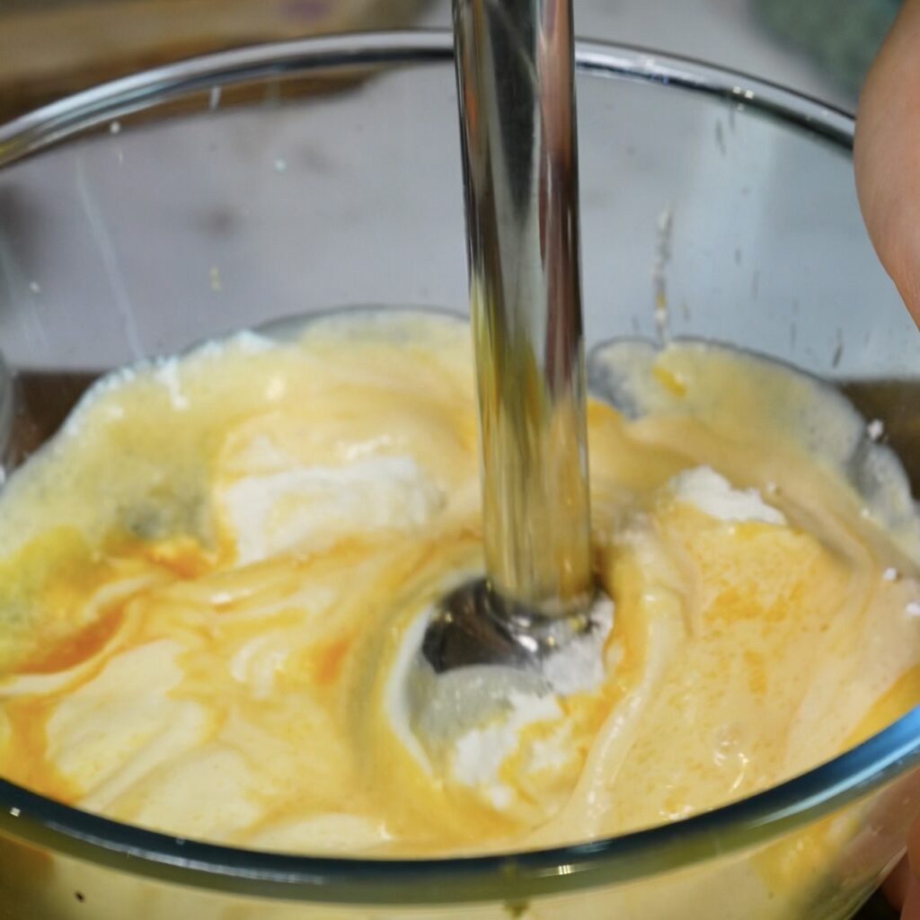 Blending ricotta, egg yolks, sugar, cornstarch, vanilla and lemon zest until smooth for Blueberry Ricotta Lasagna.