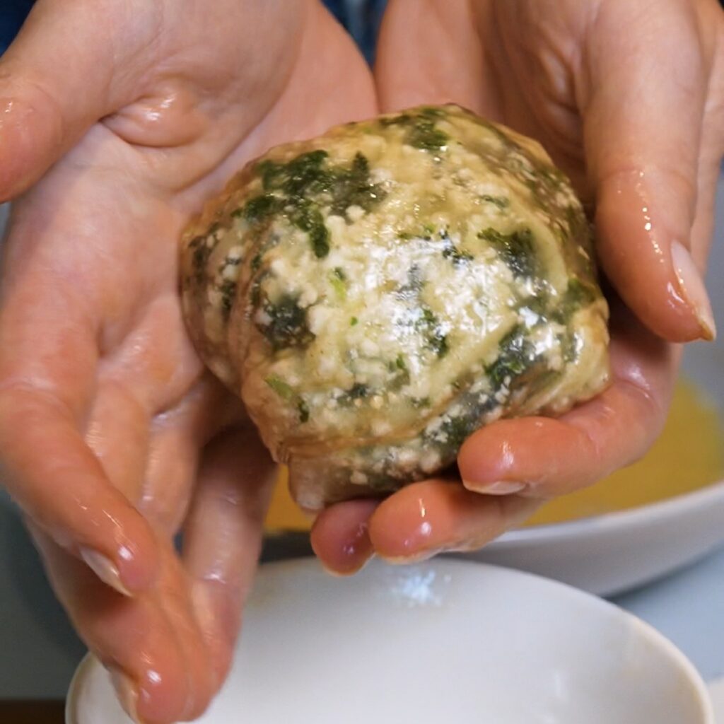 First layer of a Spinach Feta Rice Paper Bomb shaped into a round ball.