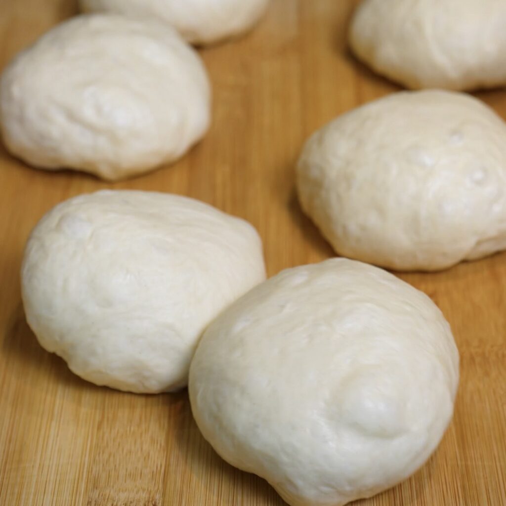 Homemade flatbread dough divided into six equal portions and shaped into smooth dough balls