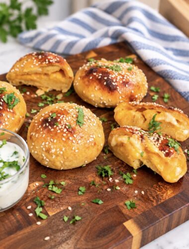 Cheesy sweet potato buns served on a wooden board.