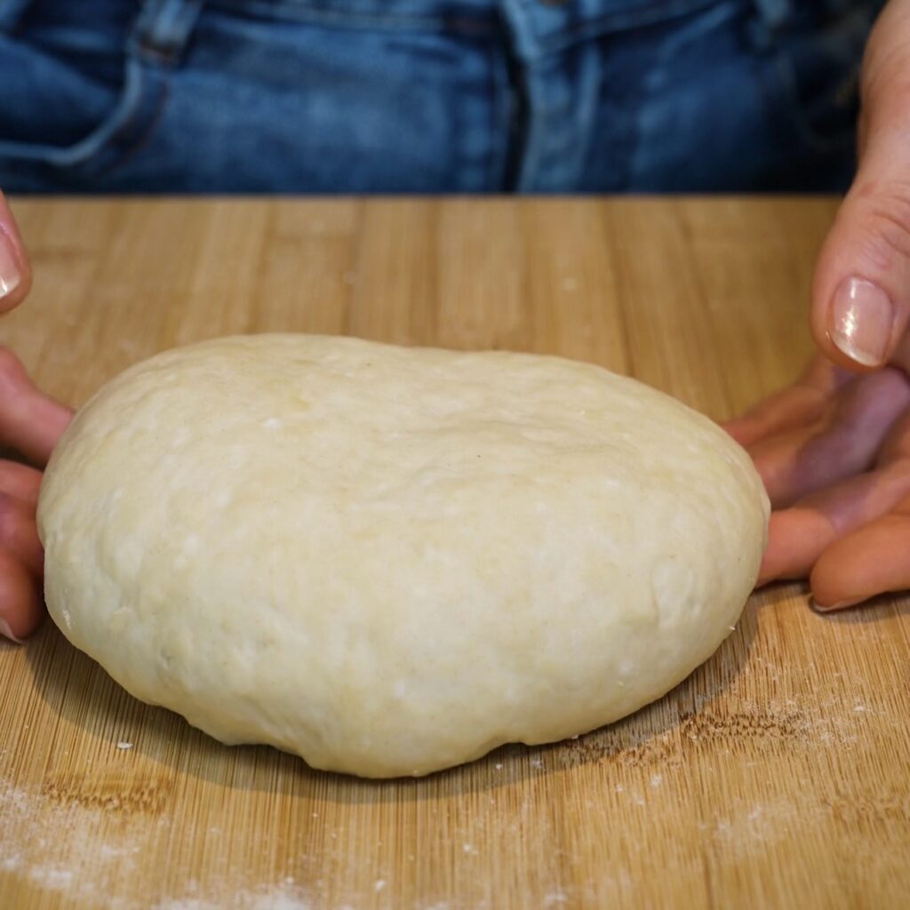 Rested Azerbaijani Qutab dough on a wooden board