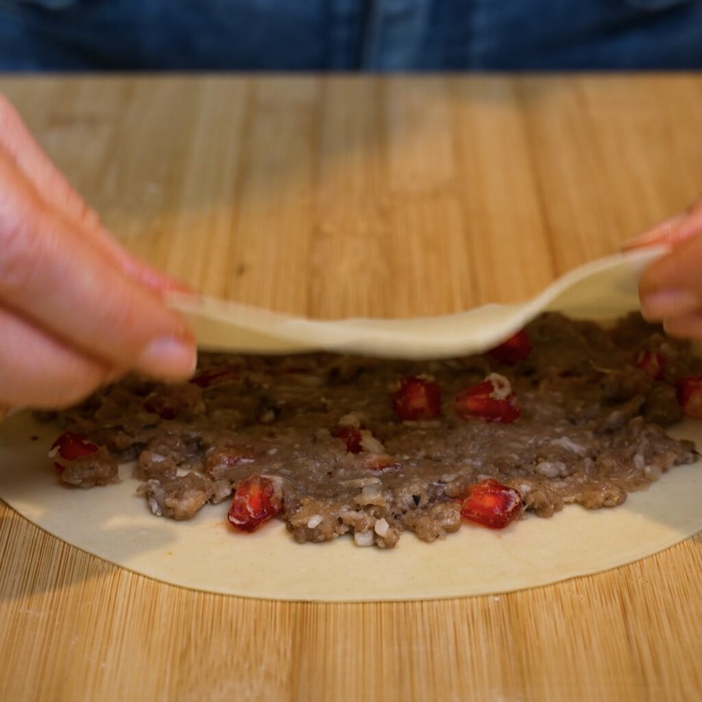 Folding qutab dough over the beef filling