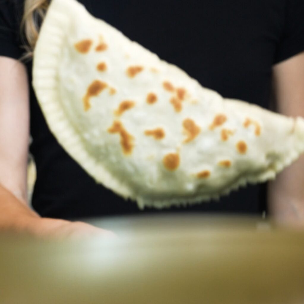 Flipping Azerbaijani Qutab in a frying pan