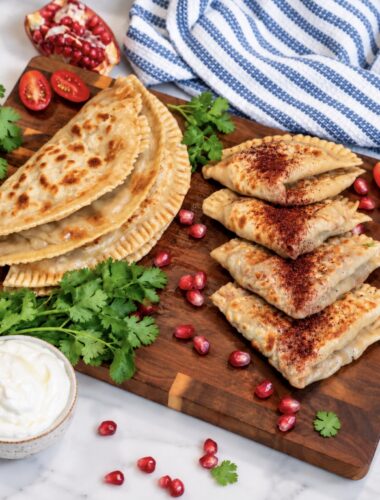 Meat-Stuffed Flatbread (Azerbaijani Qutab) served on a wooden board with sumac and yoghurt