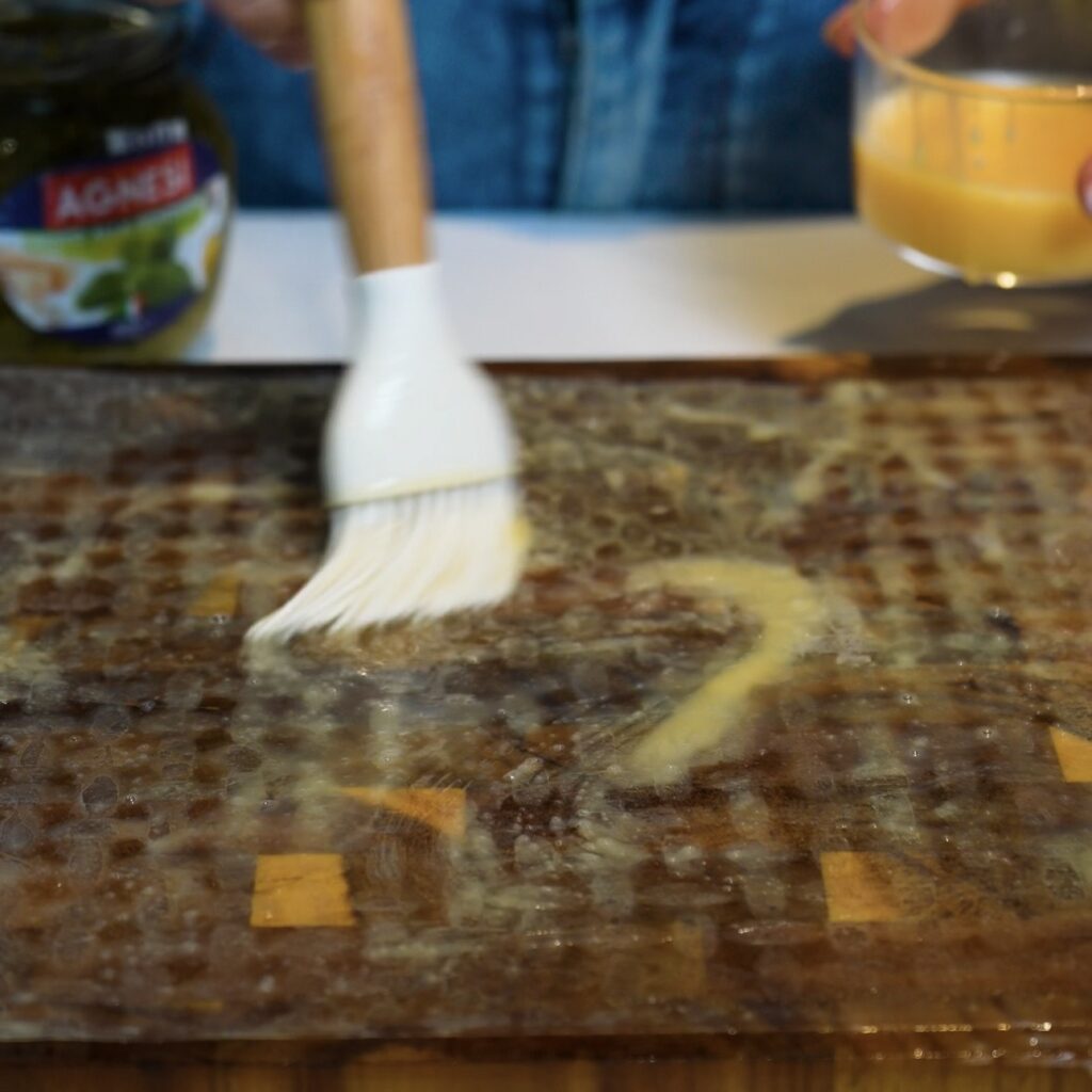 Brushing the first rice paper sheet with egg wash for Pesto Parmesan Rice Paper Twists