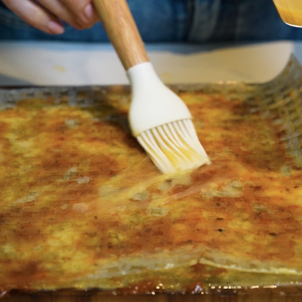 Brushing the final rice paper layer with egg wash for Pesto Parmesan Rice Paper Twists