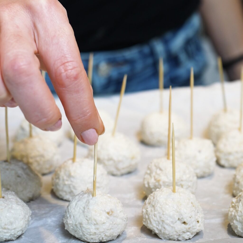 Inserting toothpicks into shaped Banana Coconut Truffles before freezing