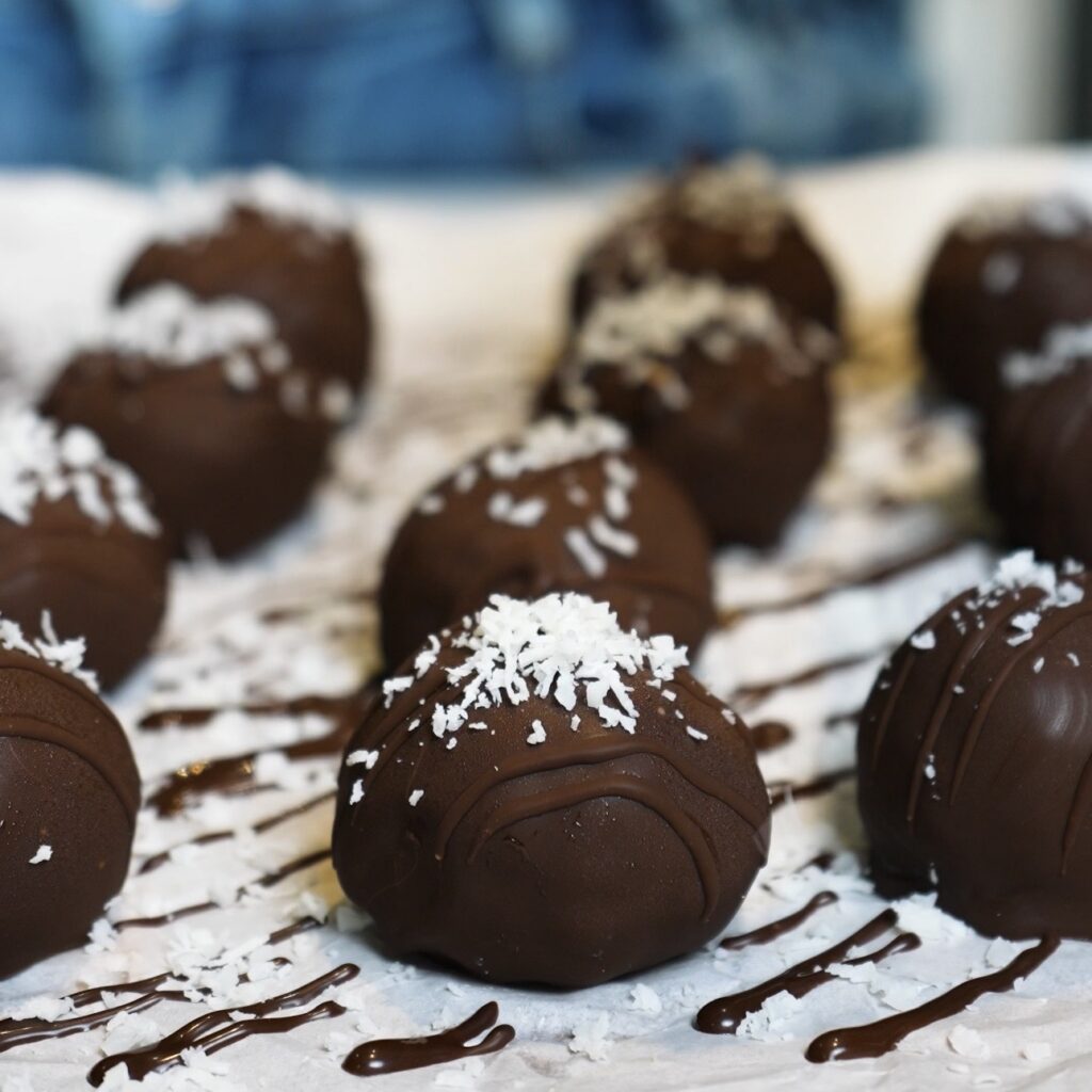 Banana Coconut Truffles drizzled with chocolate and sprinkled with desiccated coconut