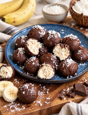 Banana Coconut Truffles served on a plate with some cut in half to show the creamy centre