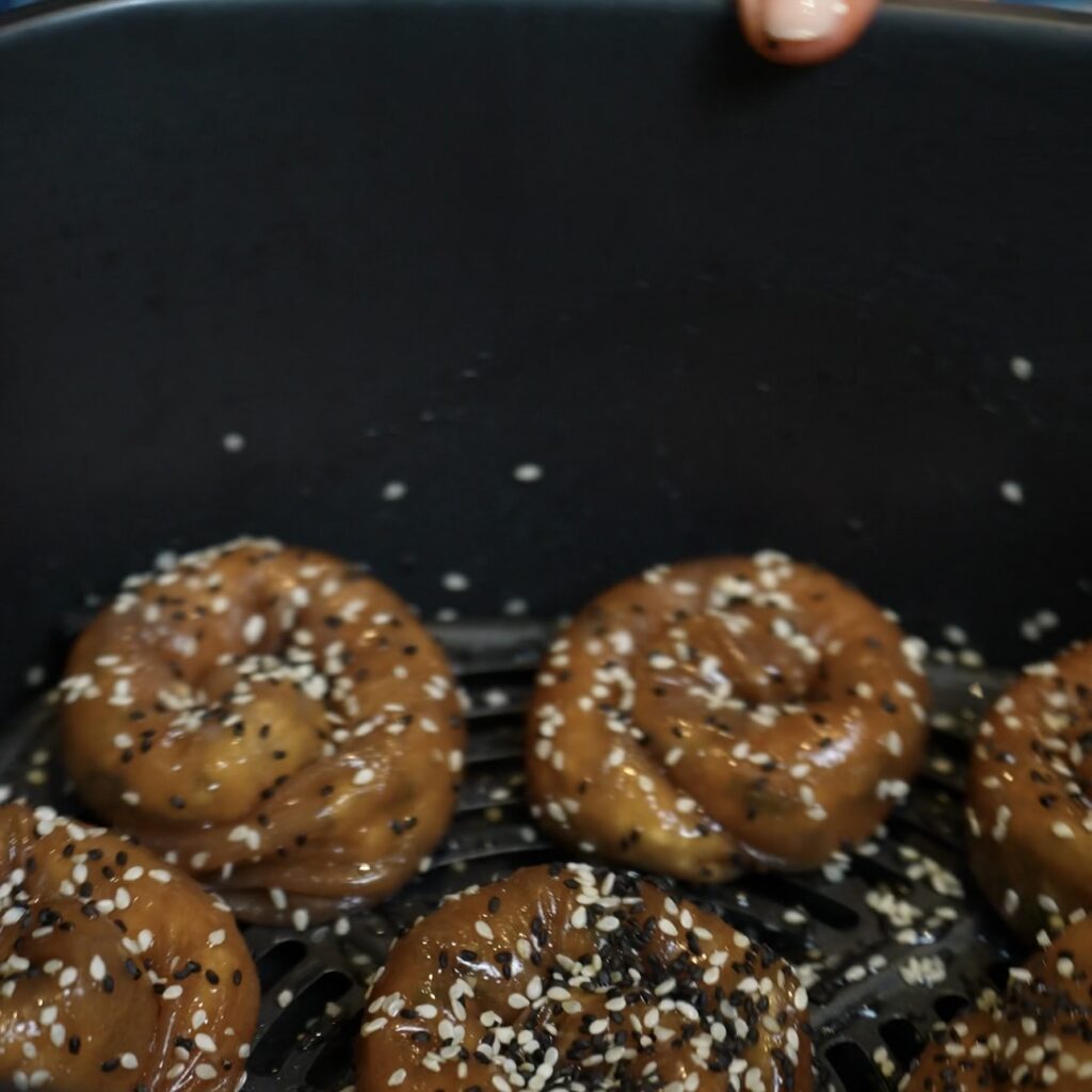 Aubergine and feta rice paper rolls sprinkled with sesame seeds before air frying
