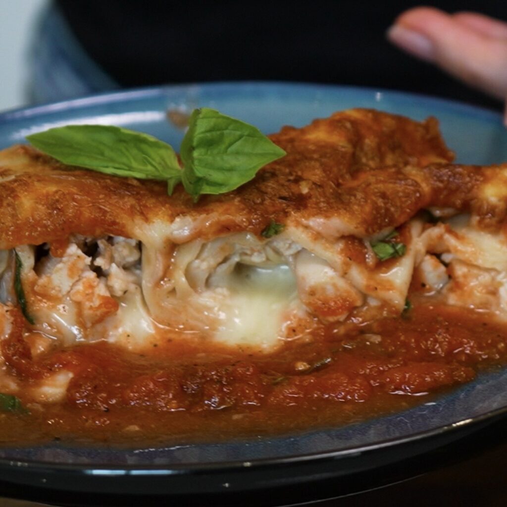 Half of 20-Minute Air Fryer Cheesy Chicken Tortilla Rolls served on a plate, revealing the chicken and mozzarella filling.