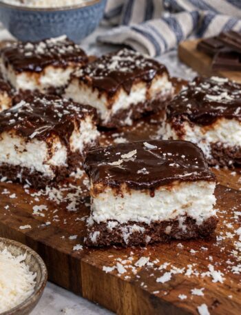 Slices of 5-Minute No-Bake Coconut Cheesecake served on a wooden board.