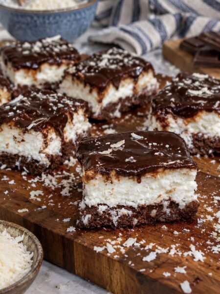 Slices of 5-Minute No-Bake Coconut Cheesecake served on a wooden board.