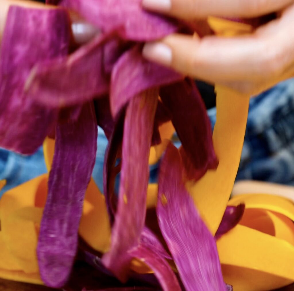 Thinly sliced butternut squash and purple sweet potato ribbons ready for assembling the gratin.